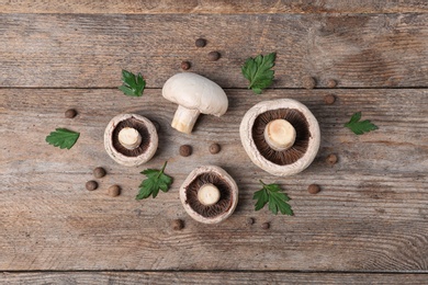 Photo of Flat lay composition with fresh champignon mushrooms on wooden background