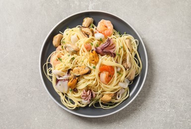 Photo of Delicious pasta with sea food on grey table, top view