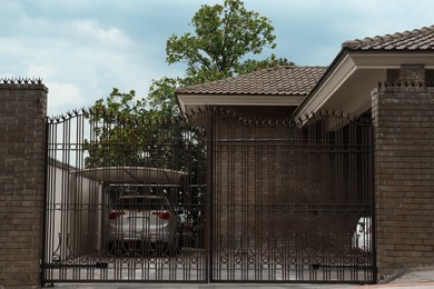 Photo of Closed metal gates near beautiful house on city street