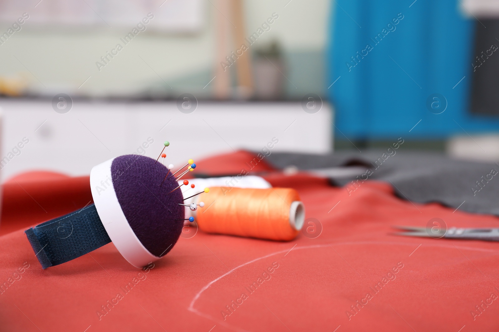 Photo of Fabric and sewing tools on table in tailor workshop, closeup