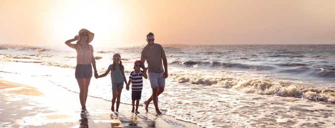 Happy family on sandy beach near sea, space for text. Banner design