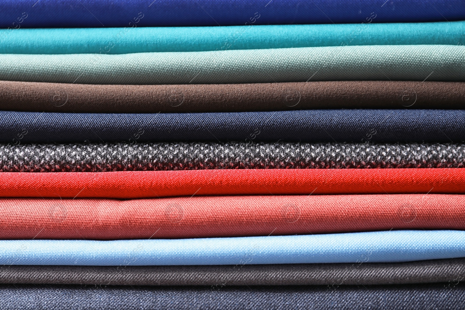 Photo of Stack of colorful fabrics as background