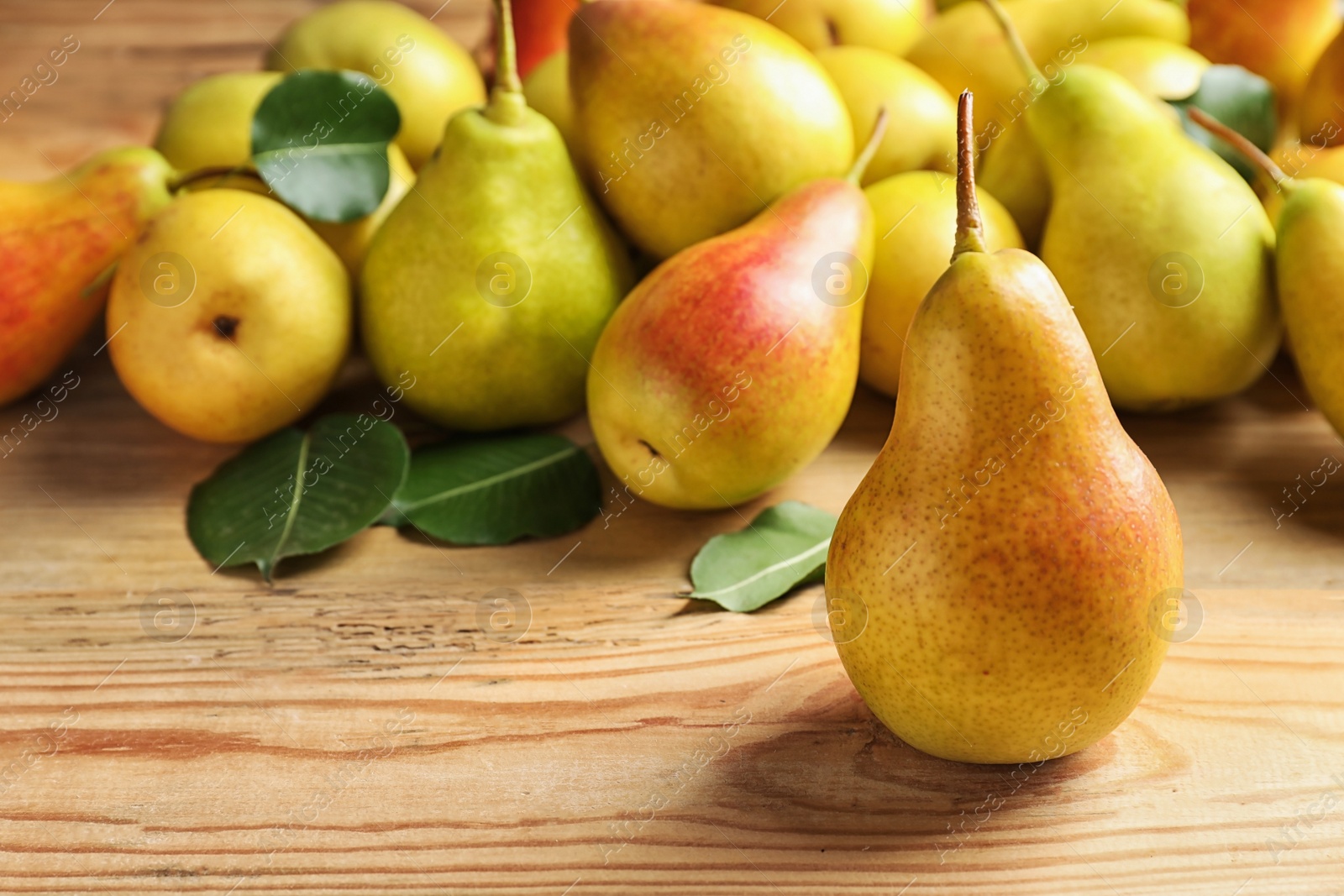 Photo of Ripe pears on wooden table. Space for text