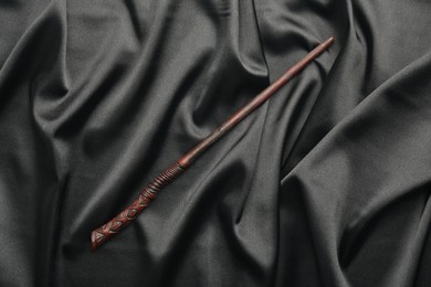 Photo of One magic wand on black fabric, top view