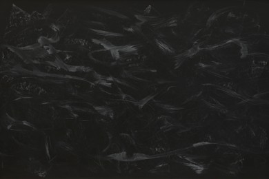 Photo of Dirty black chalkboard as background. School equipment