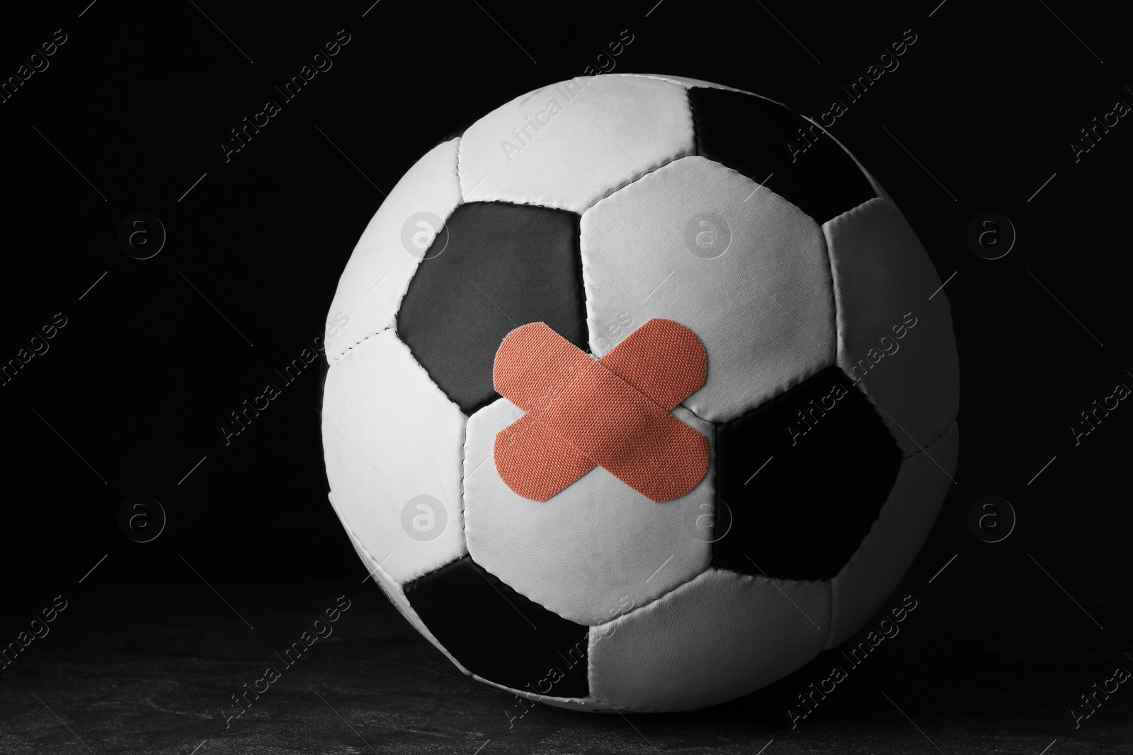 Photo of Ball with sticking plasters on grey stone table