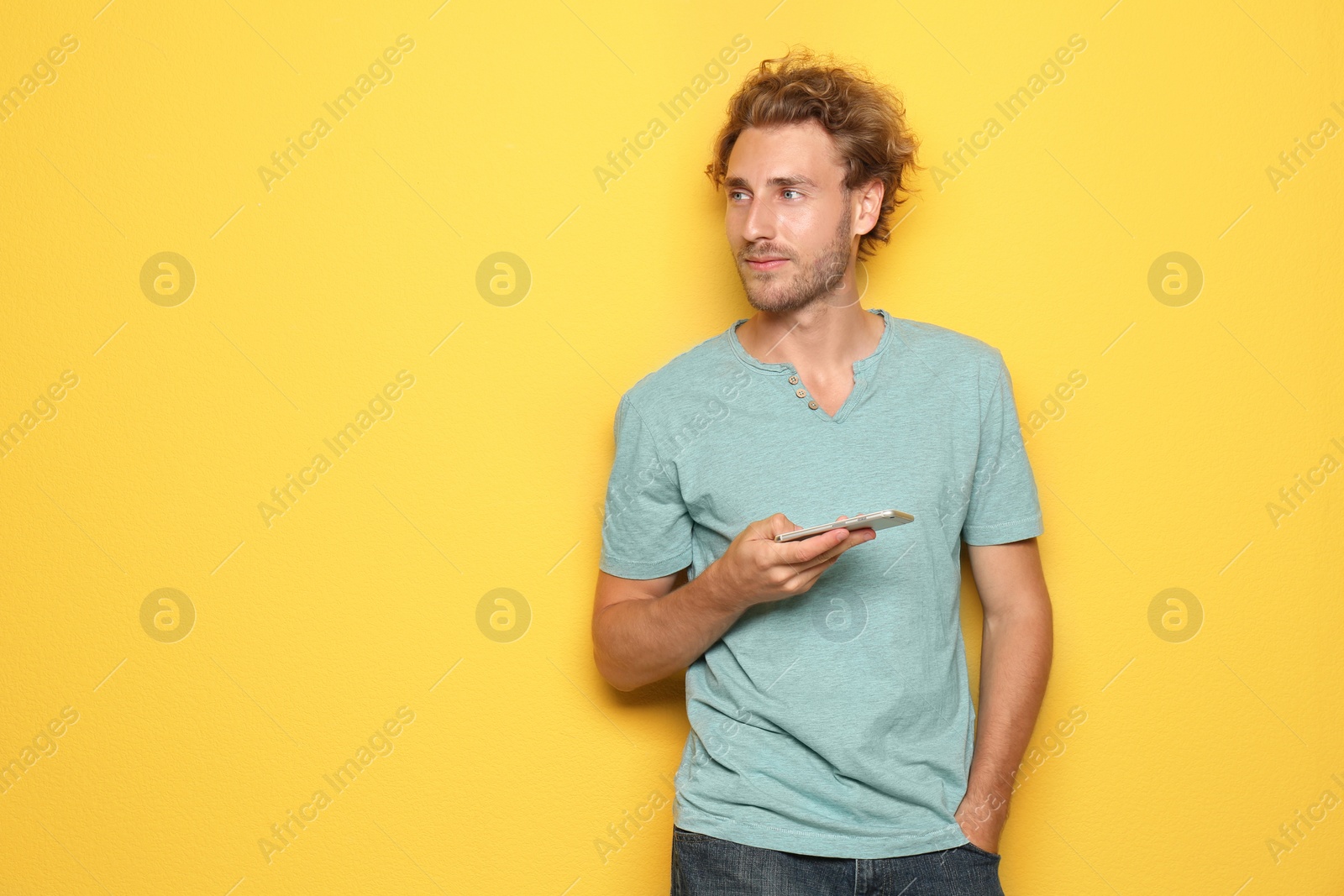 Photo of Young man with mobile phone on color background