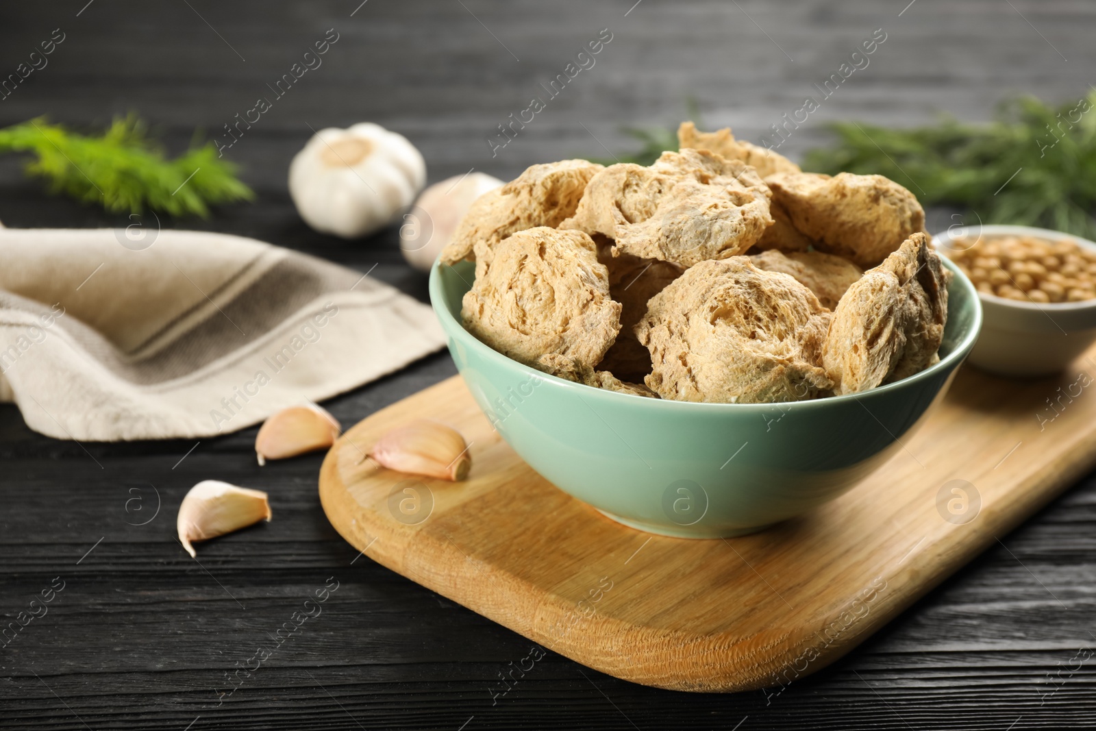 Photo of Dried soy meat in bowl on black wooden table