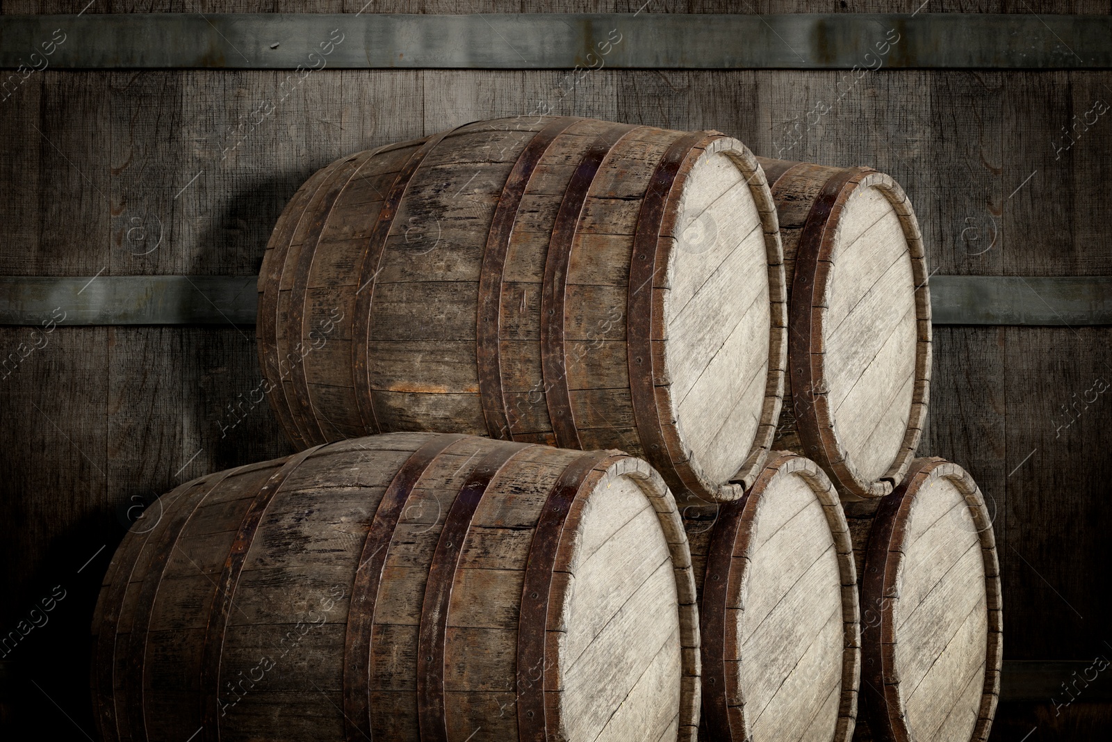 Image of Many wooden barrels near dark textured wall