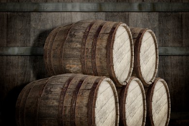 Image of Many wooden barrels near dark textured wall