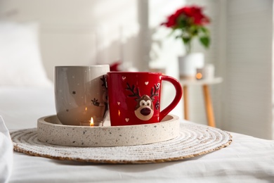 Photo of Tray with Christmas cups in room. Interior decor