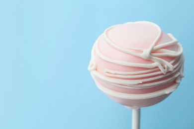 Sweet cake pop on light blue background, space for text