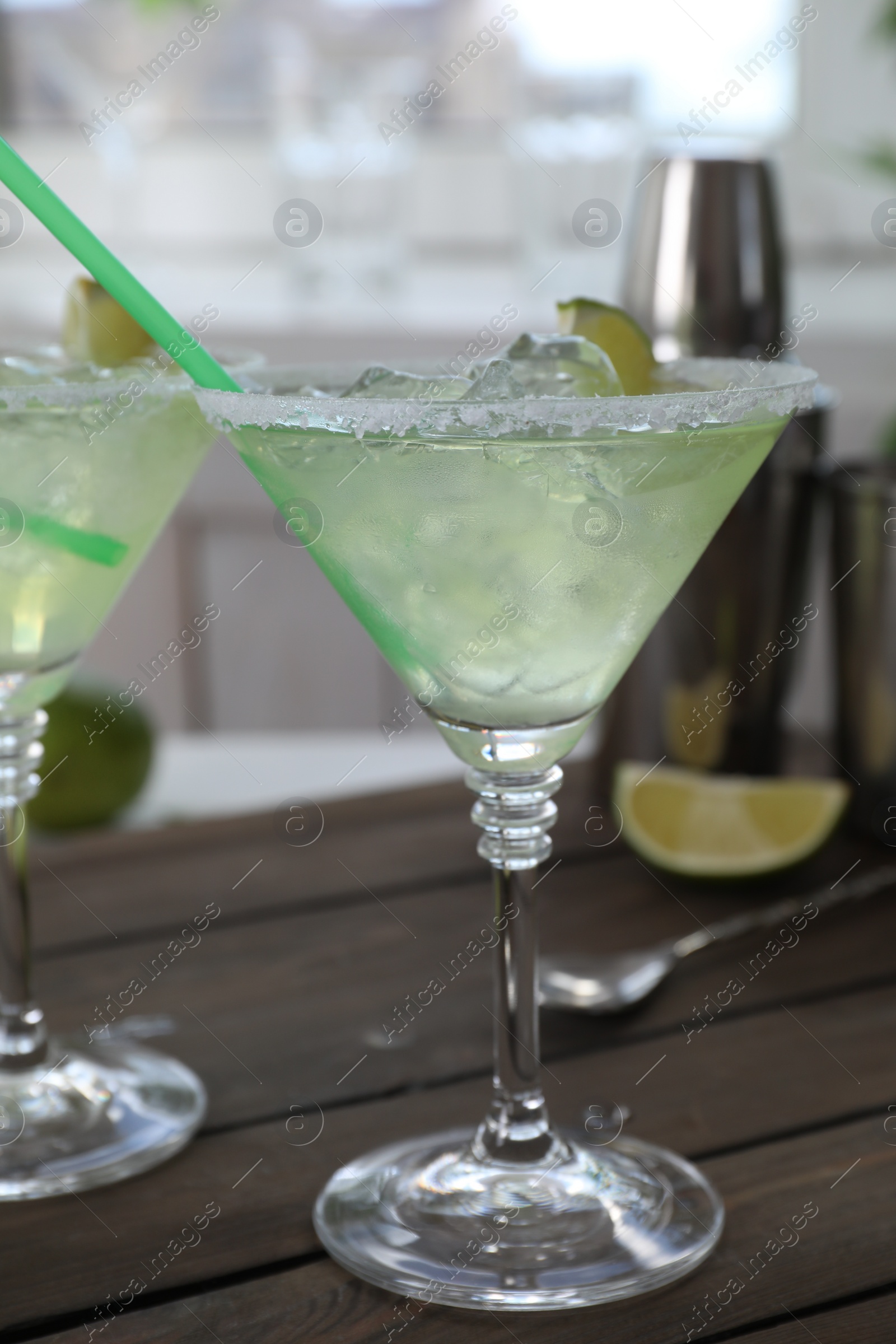 Photo of Delicious Margarita cocktail in glass on wooden table, closeup