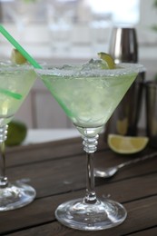 Delicious Margarita cocktail in glass on wooden table, closeup