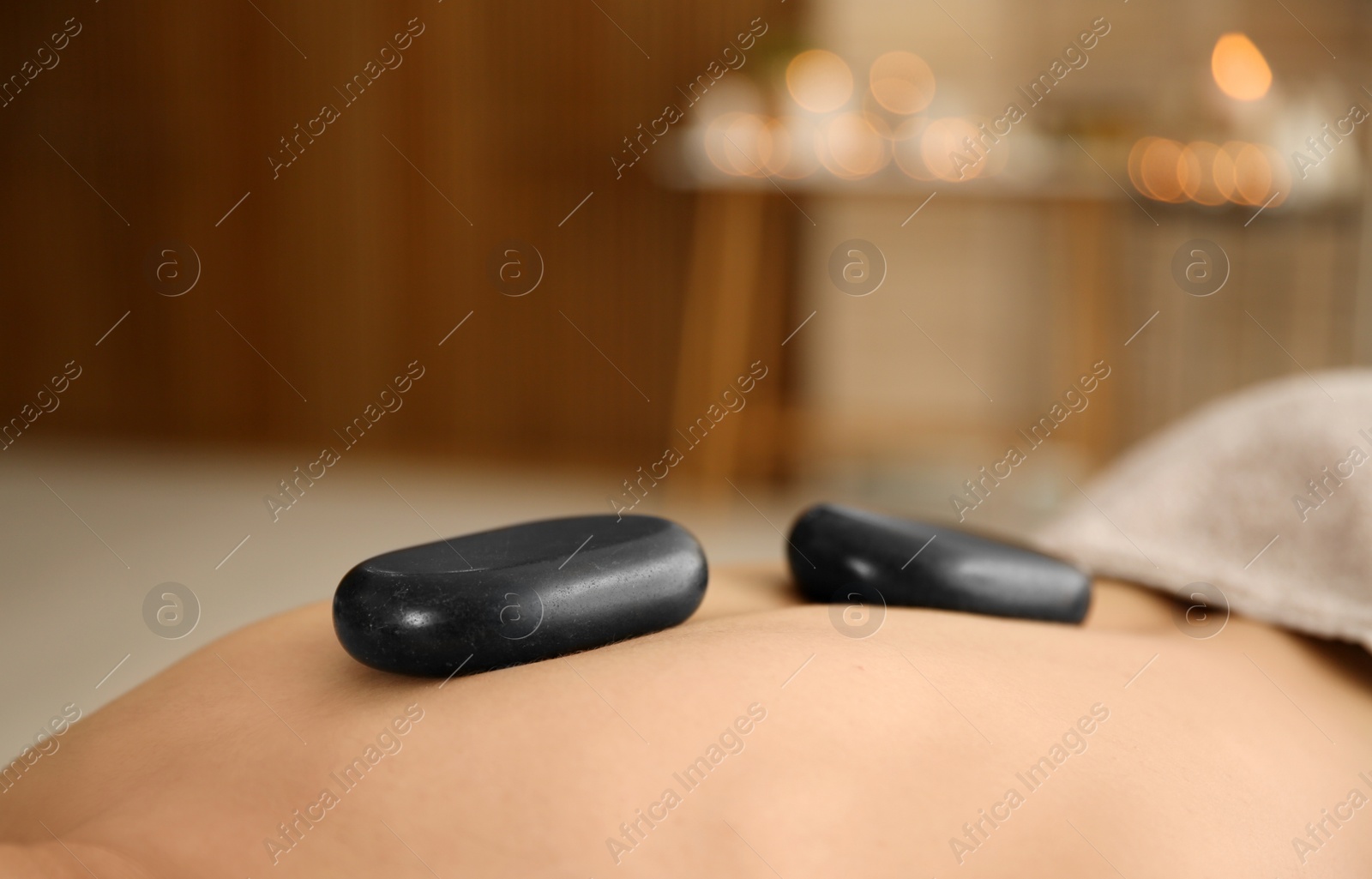 Photo of Man receiving hot stone massage in spa salon, closeup. Space for text