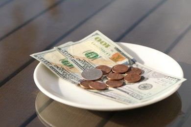 Photo of Saucer with payment for order on table, closeup. Leave tip