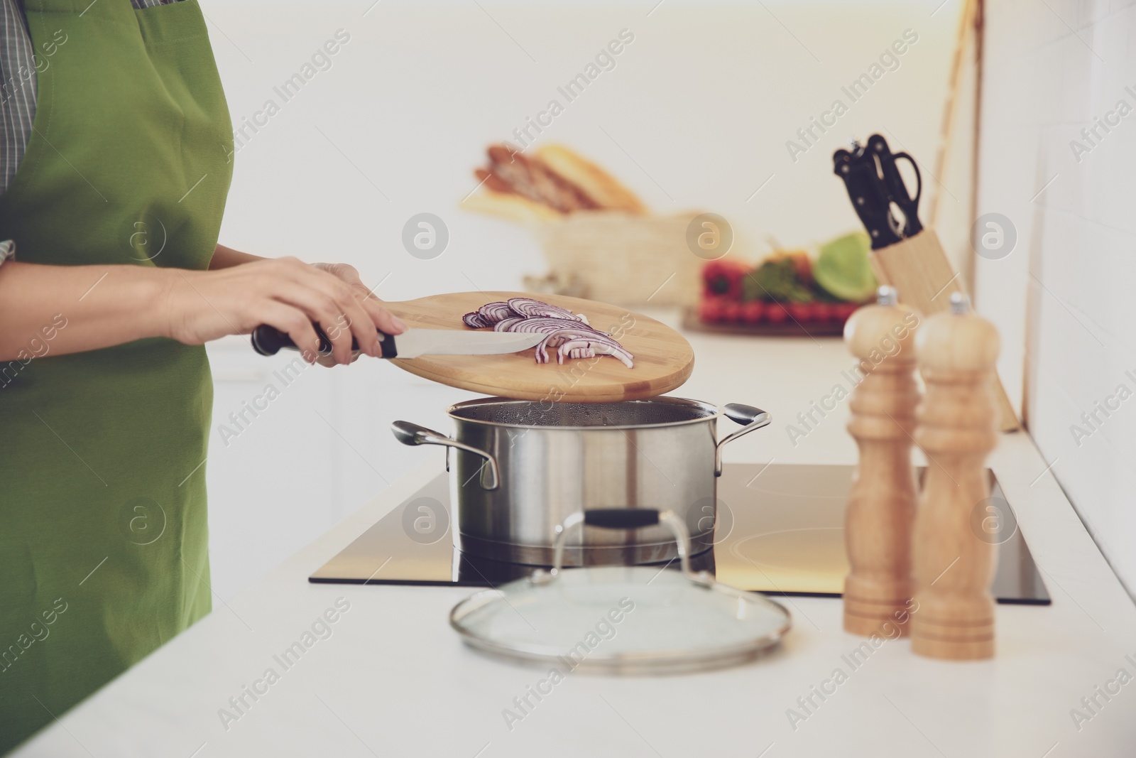 Photo of Woman cooking on stove in kitchen, closeup