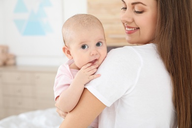 Mother holding her adorable baby at home