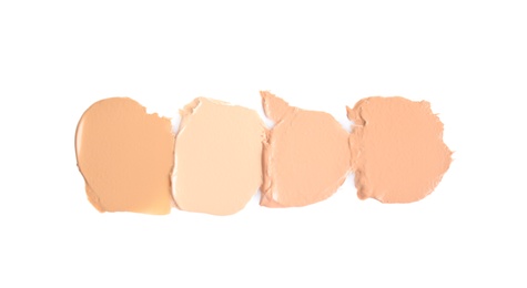 Photo of Samples of different foundation shades on white background, top view