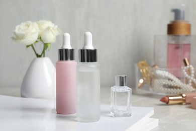Photo of Bottles of cosmetic products on light grey table