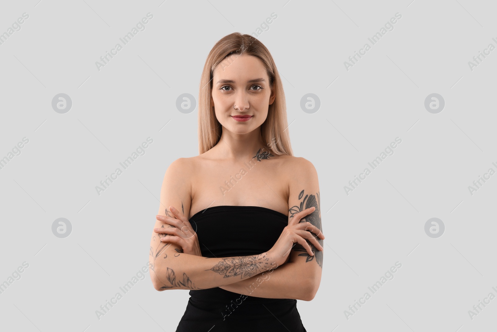 Photo of Portrait of beautiful tattooed woman on light background