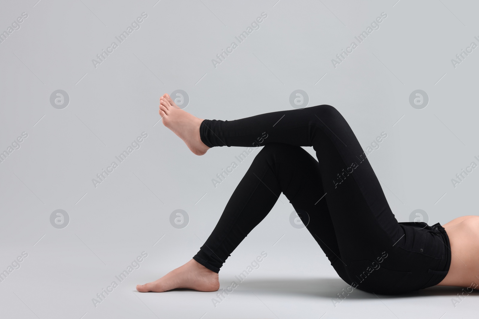 Photo of Woman wearing stylish black jeans on light gray background, closeup. Space for text