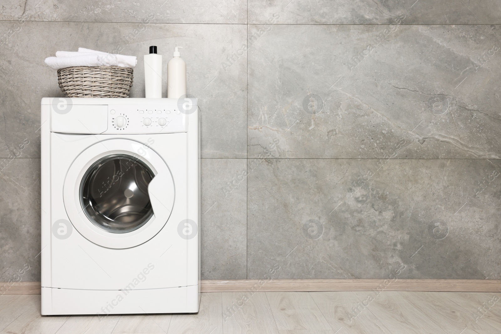 Photo of Stylish laundry room with modern washing machine, space for text. Interior design