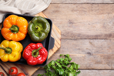 Photo of Flat lay composition with tasty stuffed bell peppers on wooden table, space for text