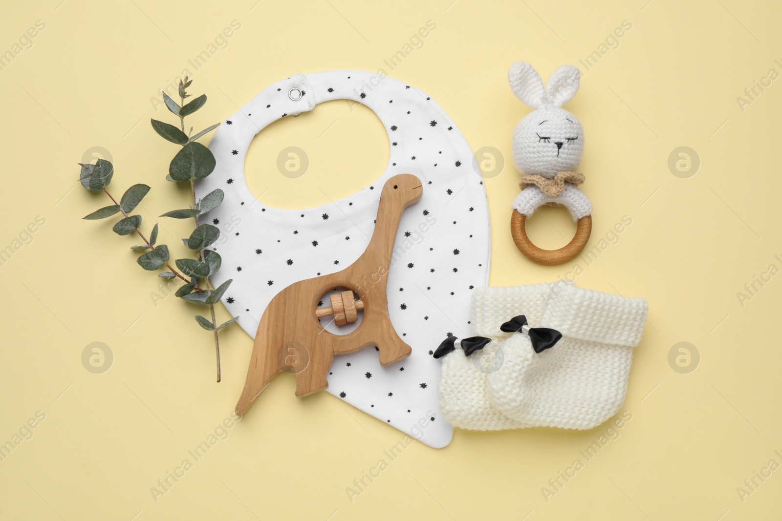 Photo of Flat lay composition with baby accessories and bib on yellow background