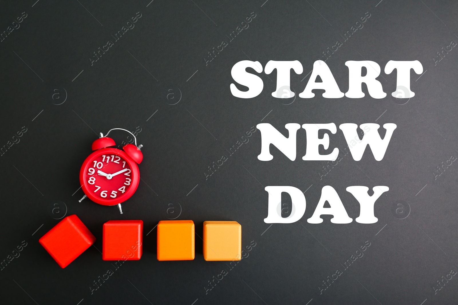 Image of Alarm clock, colorful cubes and phrase START NEW DAY on black background, flat lay