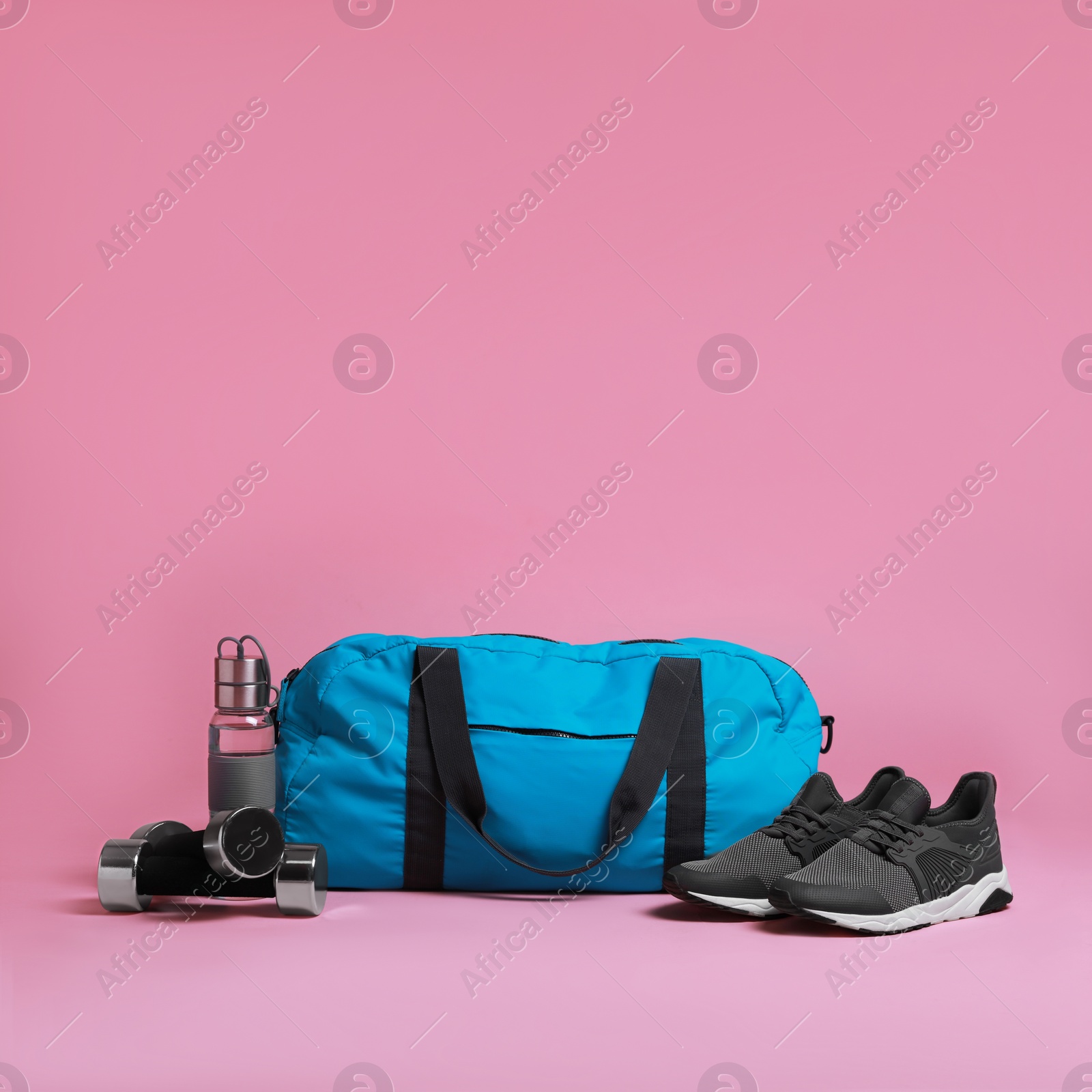 Photo of Blue gym bag and sports accessories on pink background