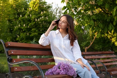 Attractive young woman talking on phone in park