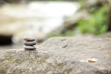 Balancing zen pebble stones outdoors against blurred background. Space for text