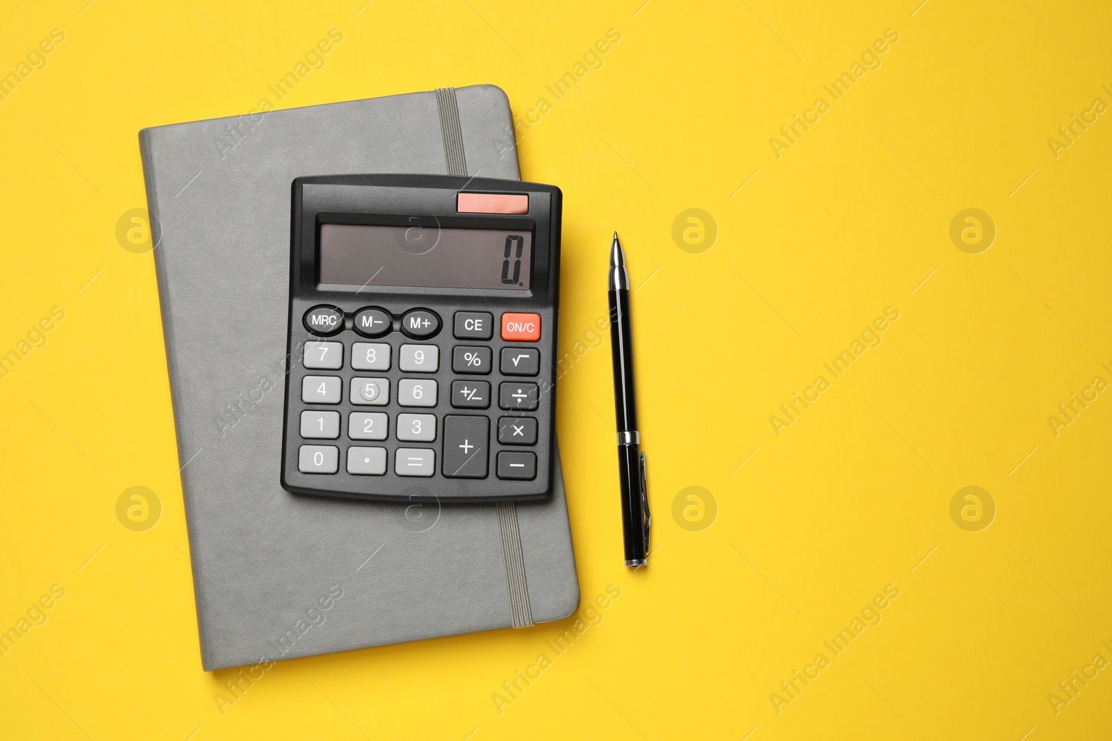 Photo of Calculator, notebook and pen on yellow background, flat lay. Space for text