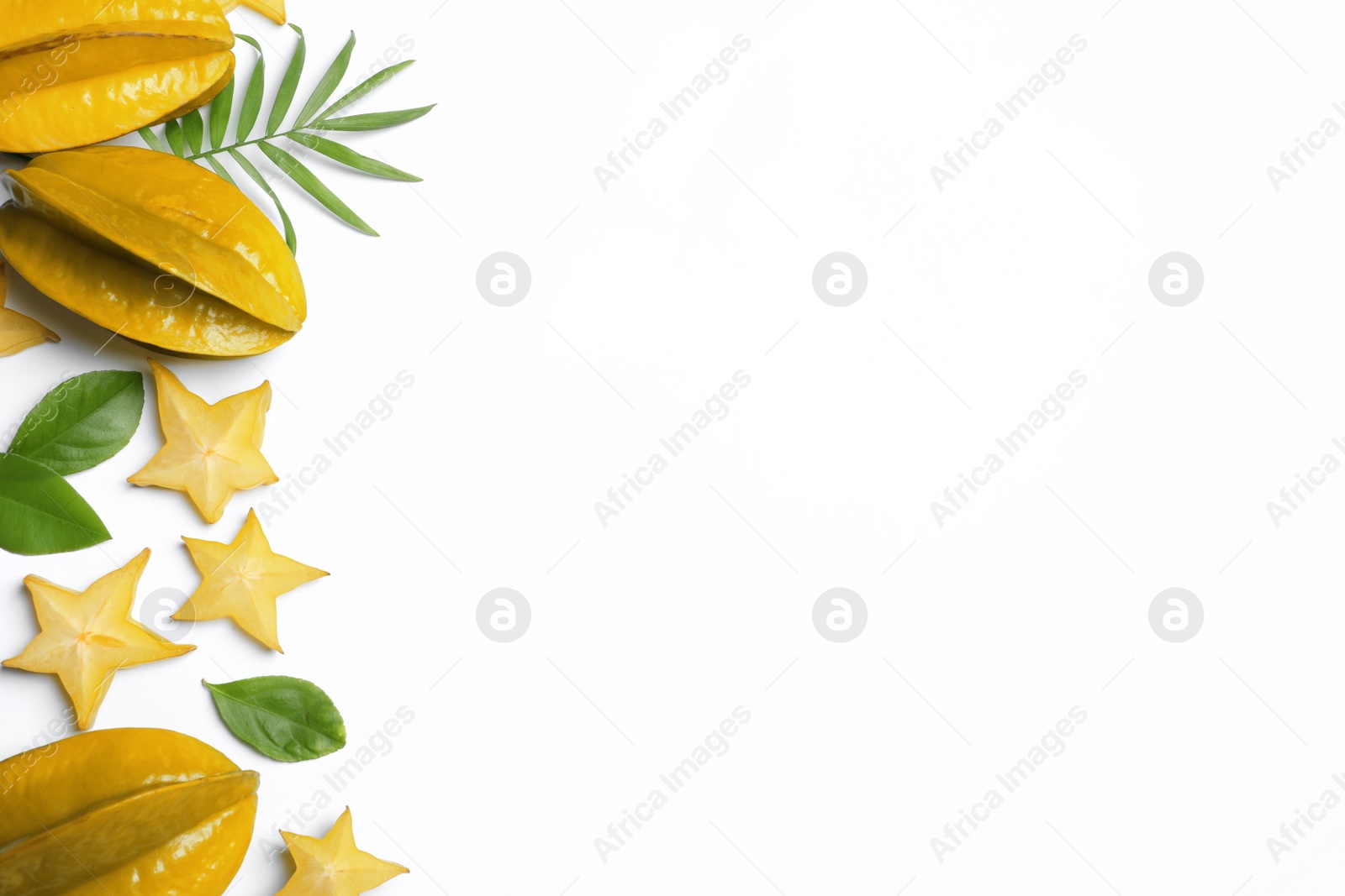 Photo of Delicious carambola fruits and leaves on white background, flat lay