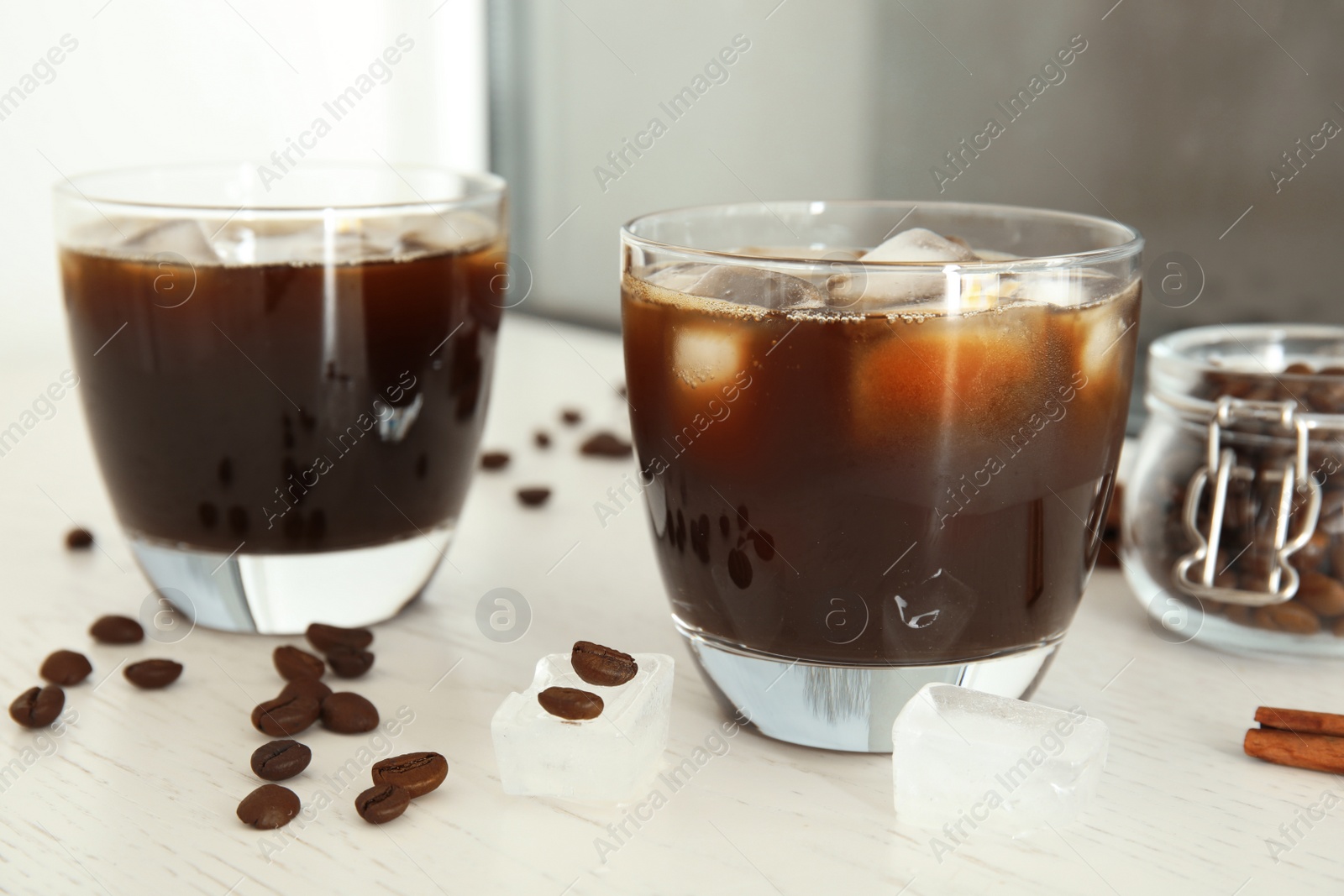 Photo of Glasses of coffee drink with ice cubes on table