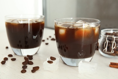 Glasses of coffee drink with ice cubes on table