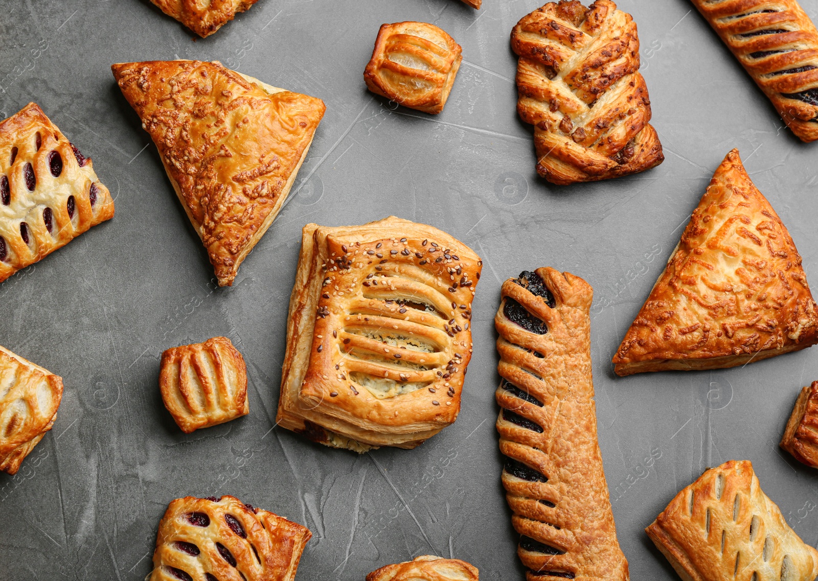 Photo of Flat lay composition with fresh delicious puff pastry on grey table