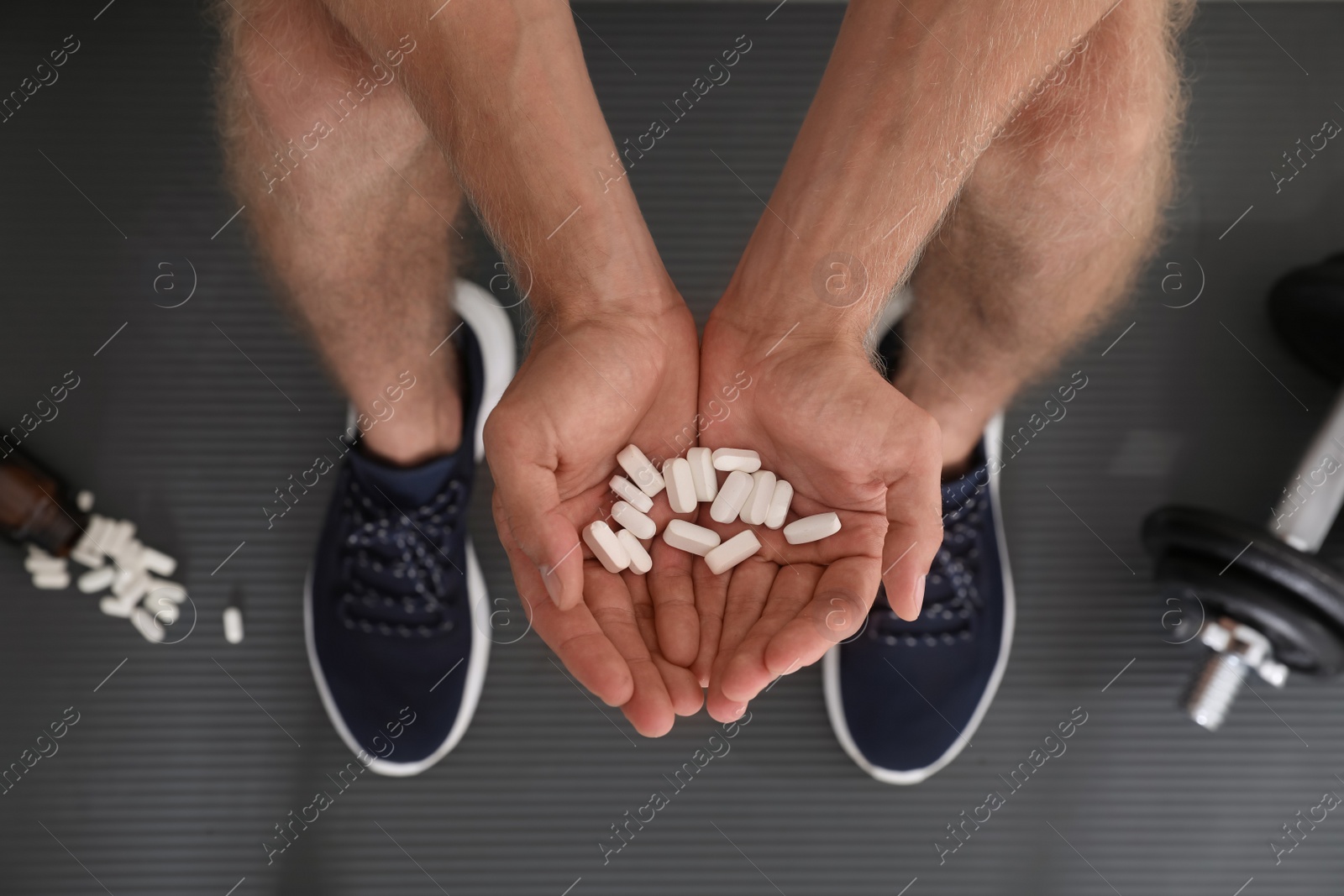 Photo of Man with handful of pills, top view. Doping concept