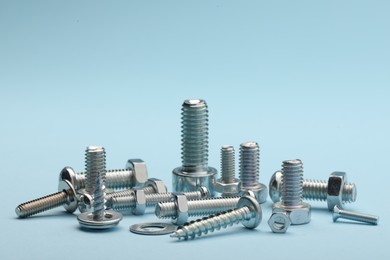 Photo of Many different fasteners on light blue background, closeup