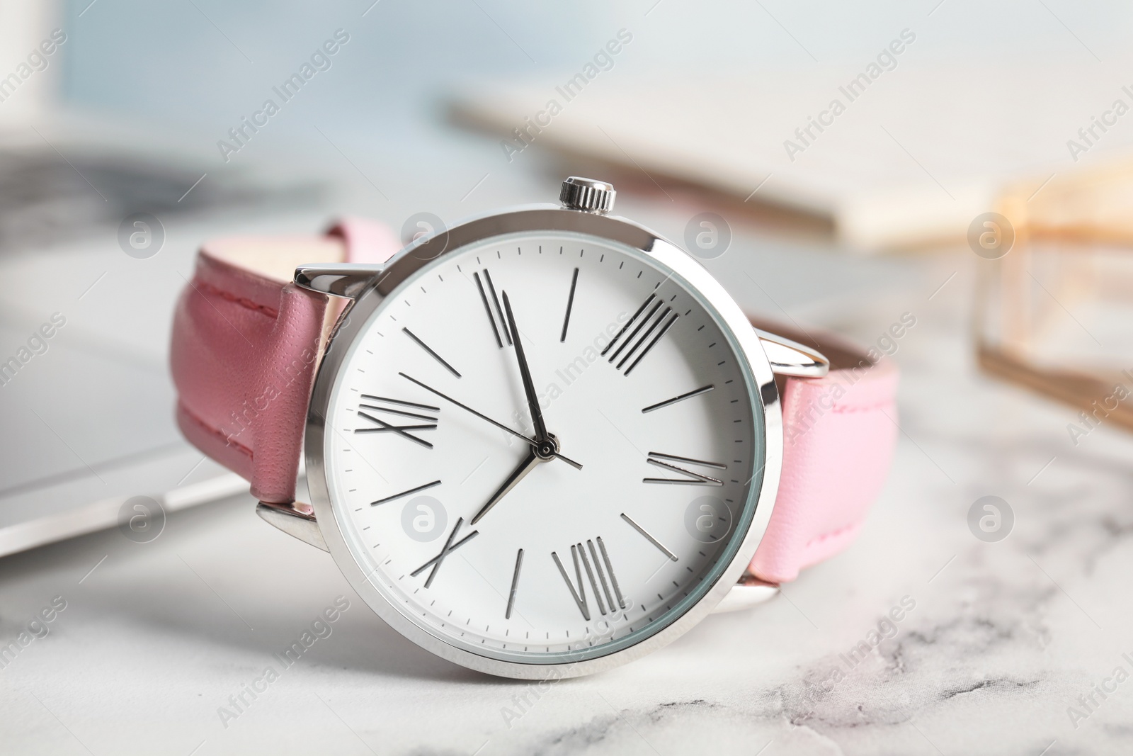 Photo of Stylish wrist watch on marble table. Fashion accessory