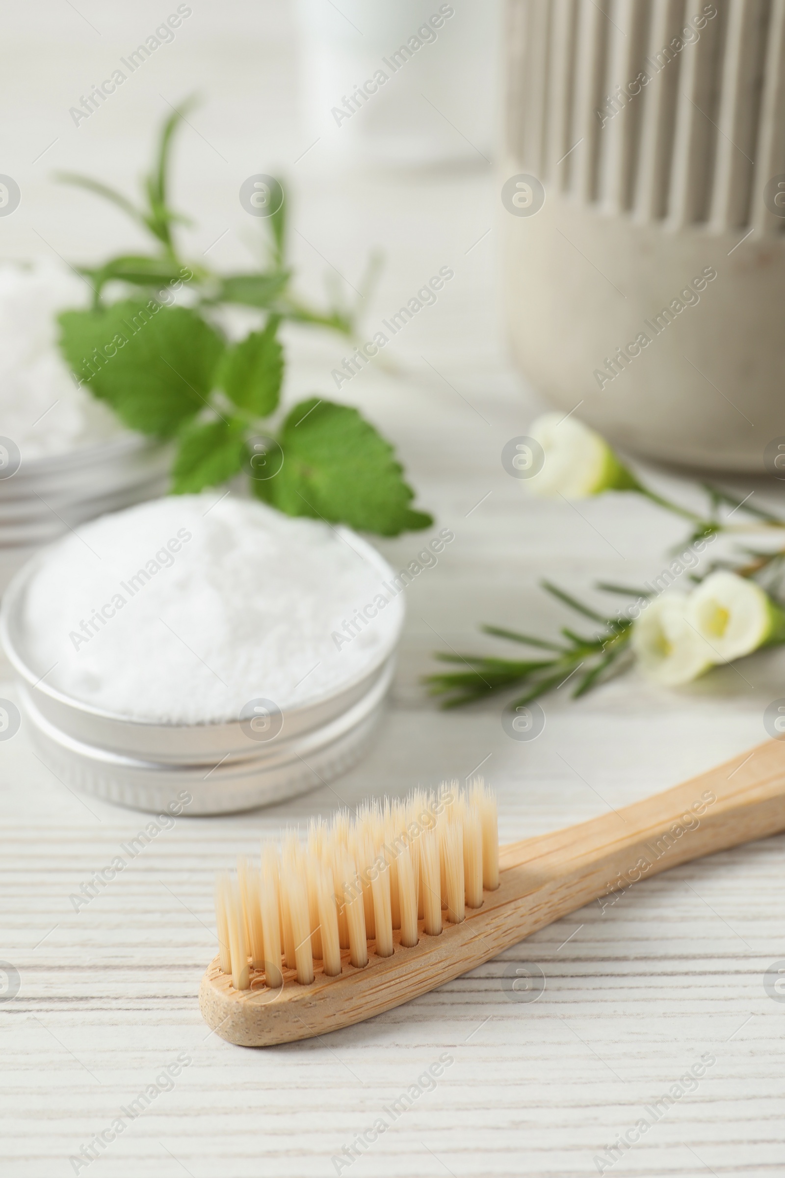 Photo of Toothbrush, dental products and herbs on white wooden table, closeup