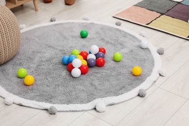 Photo of Bright toy balls and soft rug on floor in kindergarten
