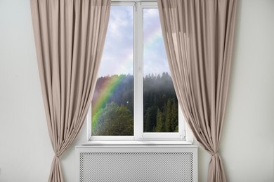 View of beautiful bright rainbow through window