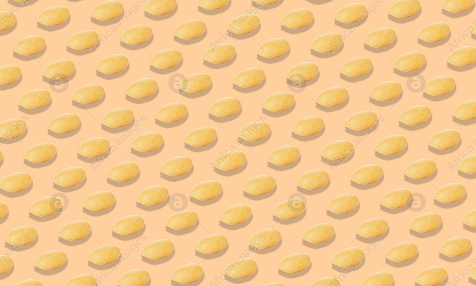 Image of Pattern of peeled peanuts on beige background