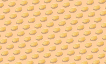 Pattern of peeled peanuts on beige background