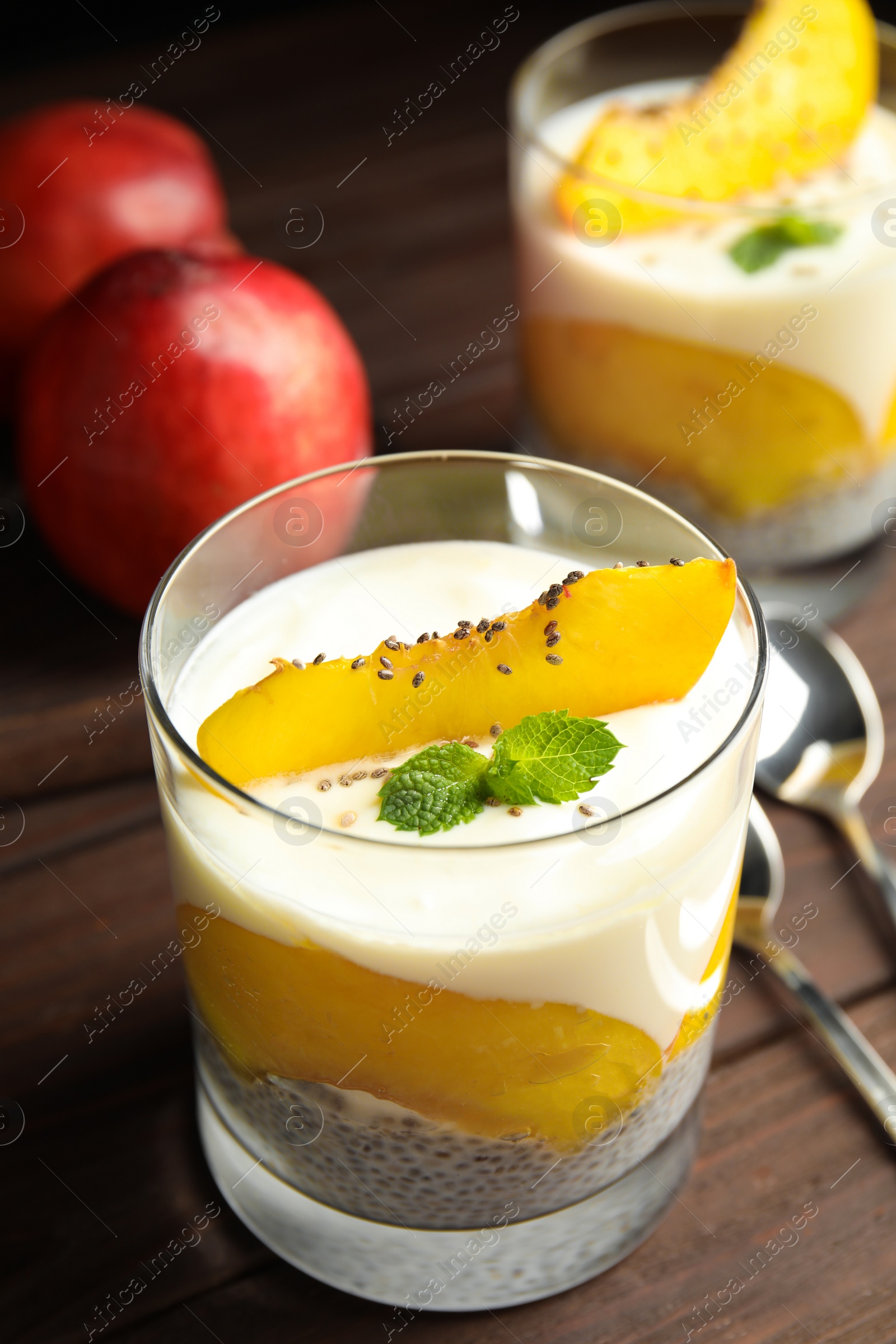 Photo of Tasty peach dessert with yogurt and chia seeds served on wooden table