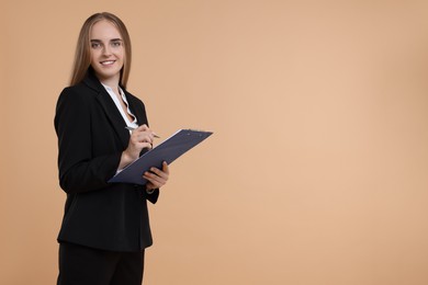 Photo of Happy young secretary with clipboard and pen on beige background, space for text