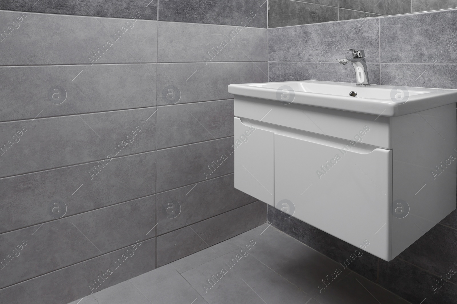 Photo of Public toilet interior with stylish white sinks and grey tiles