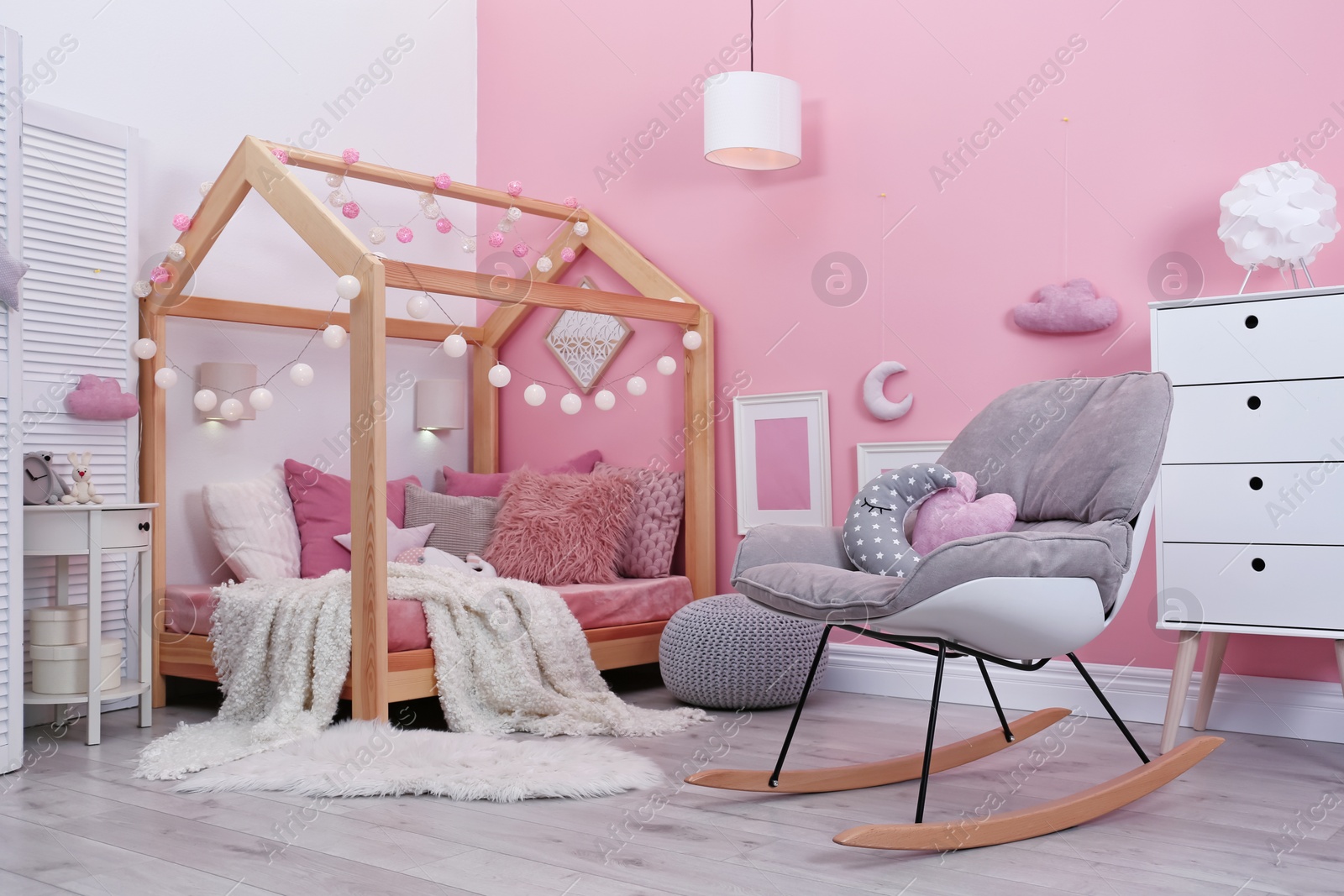 Photo of Child's room interior with comfortable bed and garland